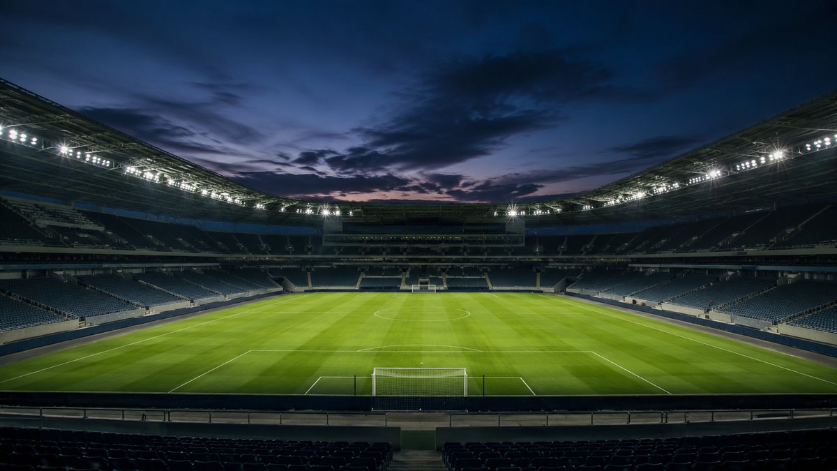 Estádio de futebol iluminado ao entardecer, vazio antes do jogo — amistoso Brasil x Egito