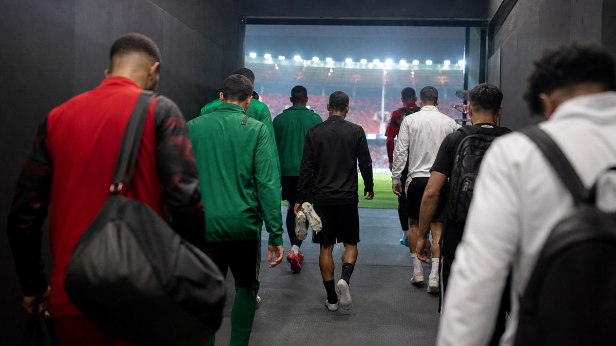 Jogadores de clubes brasileiros caminham por um tunel de estadio antes de partida internacional.