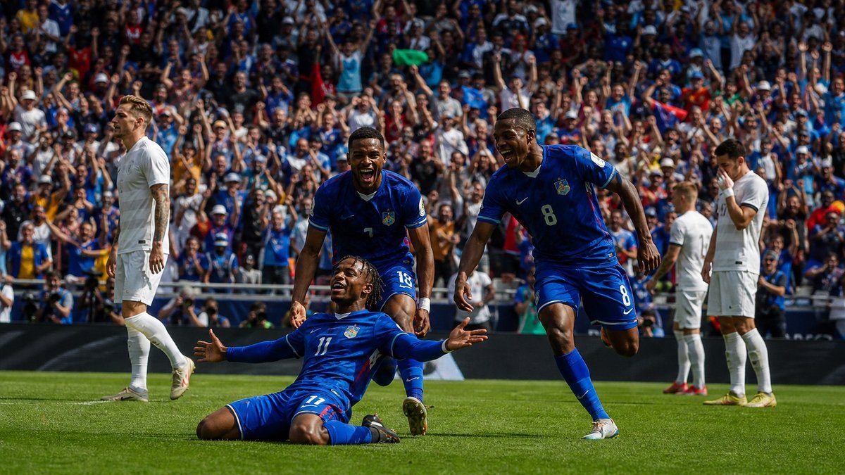 Jogadores de uma seleção caribenha celebram um gol em estádio de Copa do Mundo.