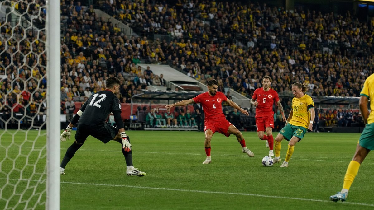 Jogadores de Austrália e Turquia disputam bola dentro da área em estádio lotado durante jogo da Copa