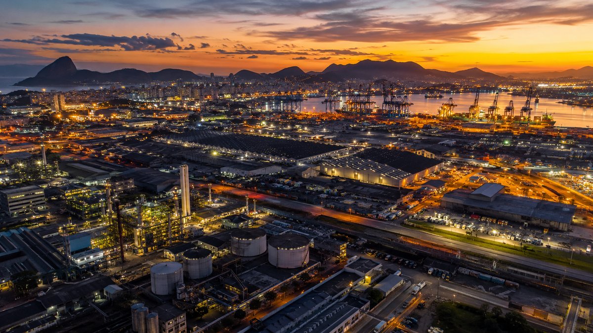 Vista aérea de distrito industrial e portuário brasileiro ao entardecer — crescimento do PIB