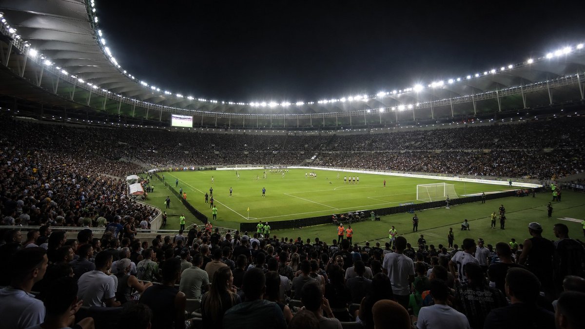 Estádio de futebol iluminado à noite antes de uma partida decisiva