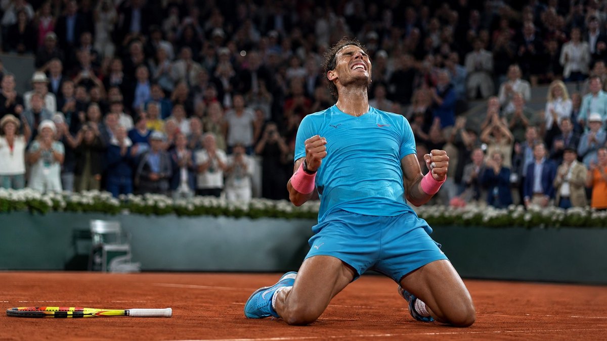 Tenista celebrando em uma quadra de saibro após vencer uma final de Grand Slam.
